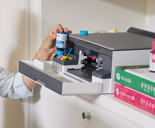 Imagem de uma pessoa colocando frascos de tinta em uma impre...