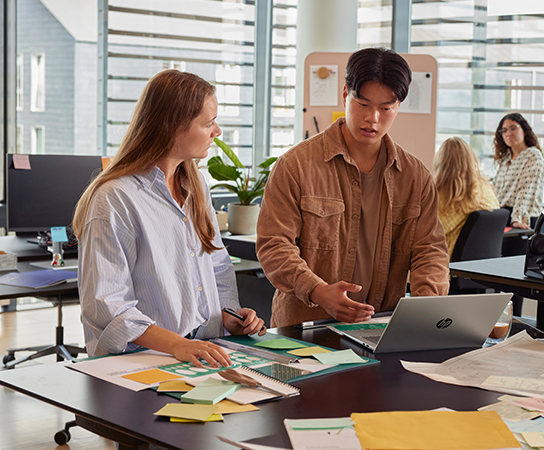 Mulher e homem trabalhando em um laptop HP em um escritório.